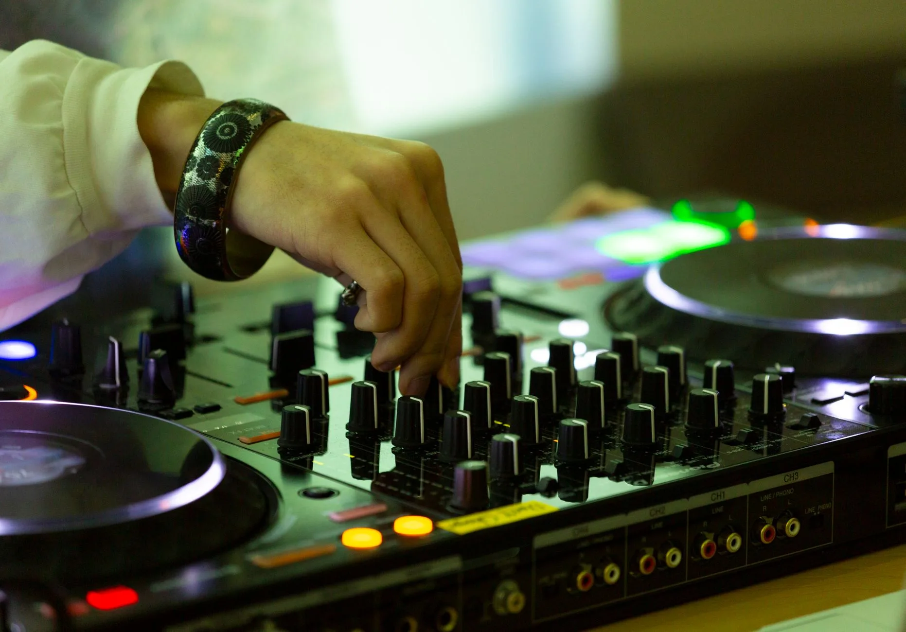Vibe coding — Close-up de um DJ mixando faixas em um console em uma boate de Tóquio, criando uma atmosfera noturna vibra